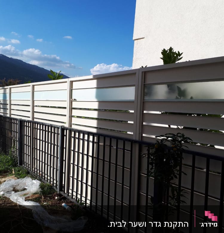 גדרות מתכת ולוחות זכוכית חלבית בחצר